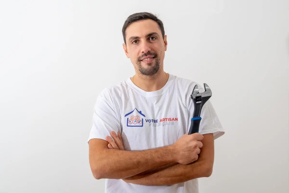 Benoît, artisan plombier, avec une clé à molette à Nice