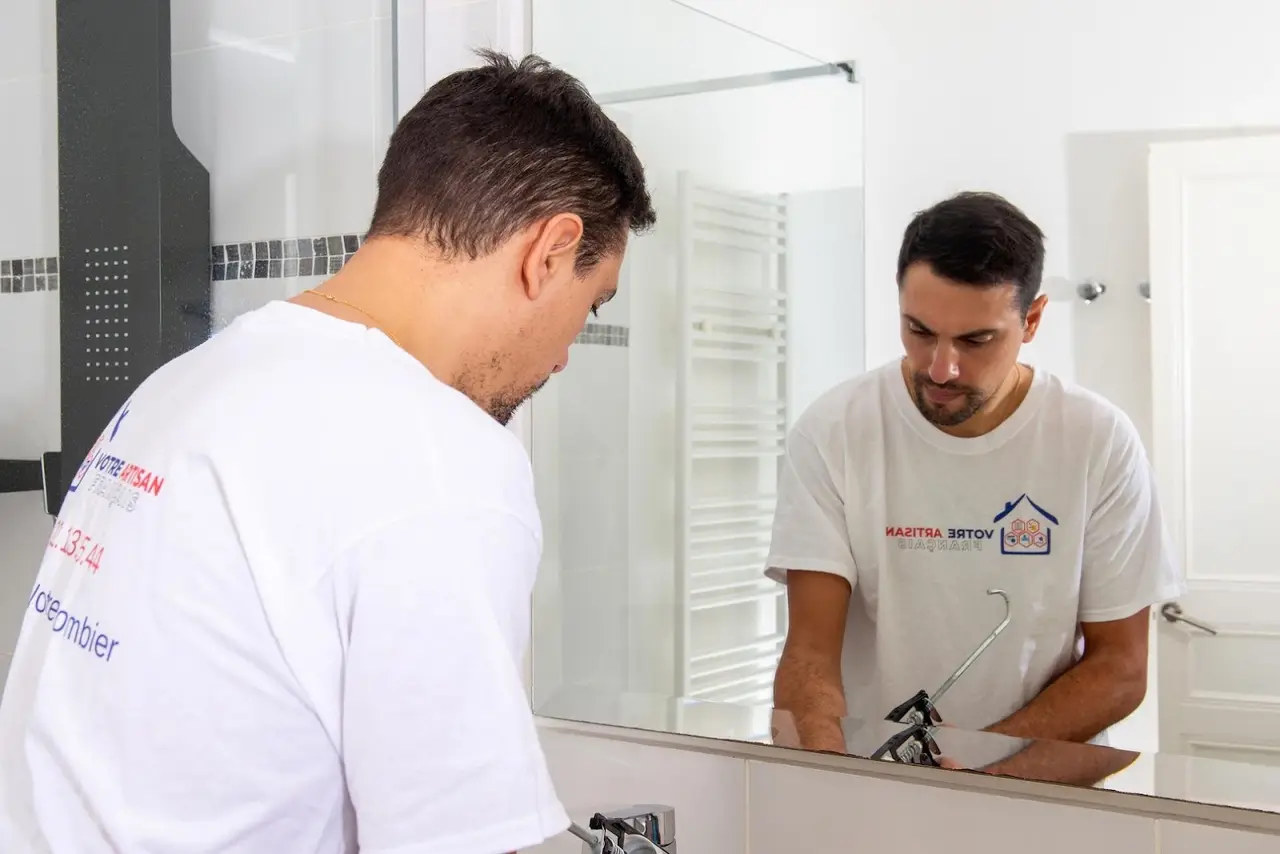 Application de silicone autour d'un robinet de lavabo par un plombier à Nice