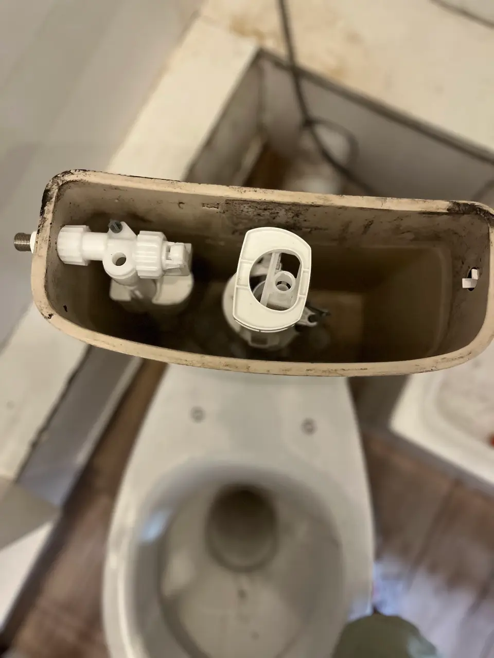 Réservoir WC démonté, mécanisme de vidange visible à Nice