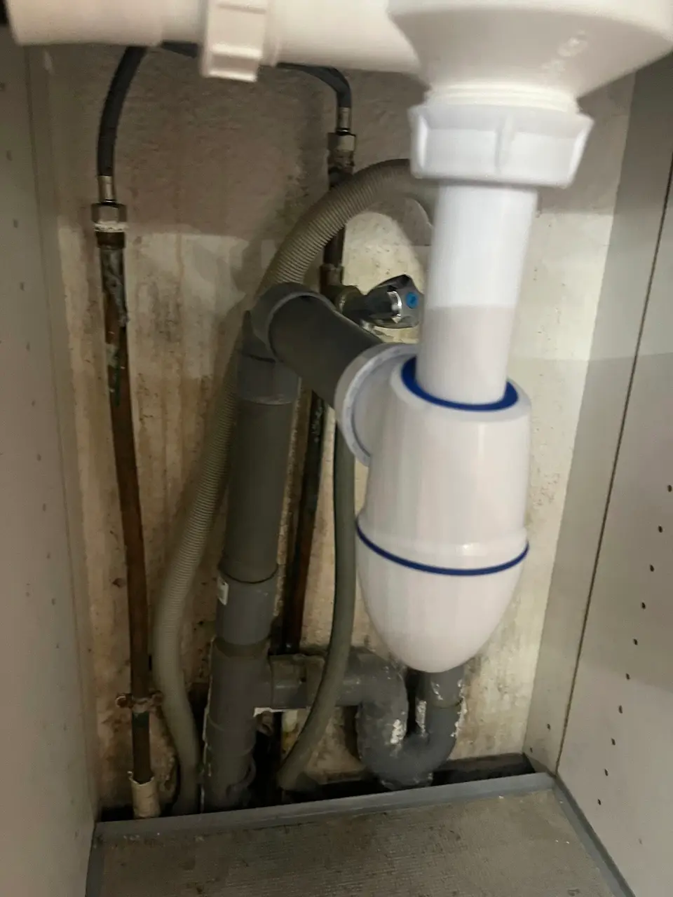 Siphon bouteille neuf raccordé sous un lavabo à Nice